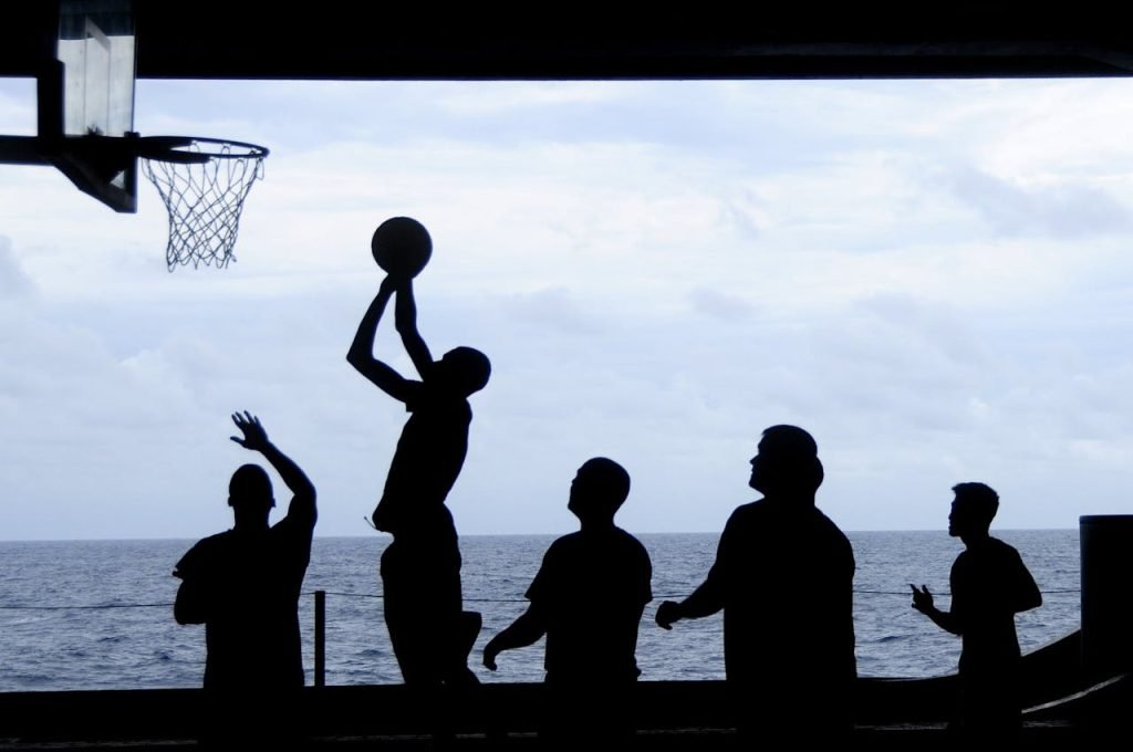 silhouette-of-men-playing-basketball-69773 Silhouette of a basketball game played by the ocean, creating a striking visual scene.